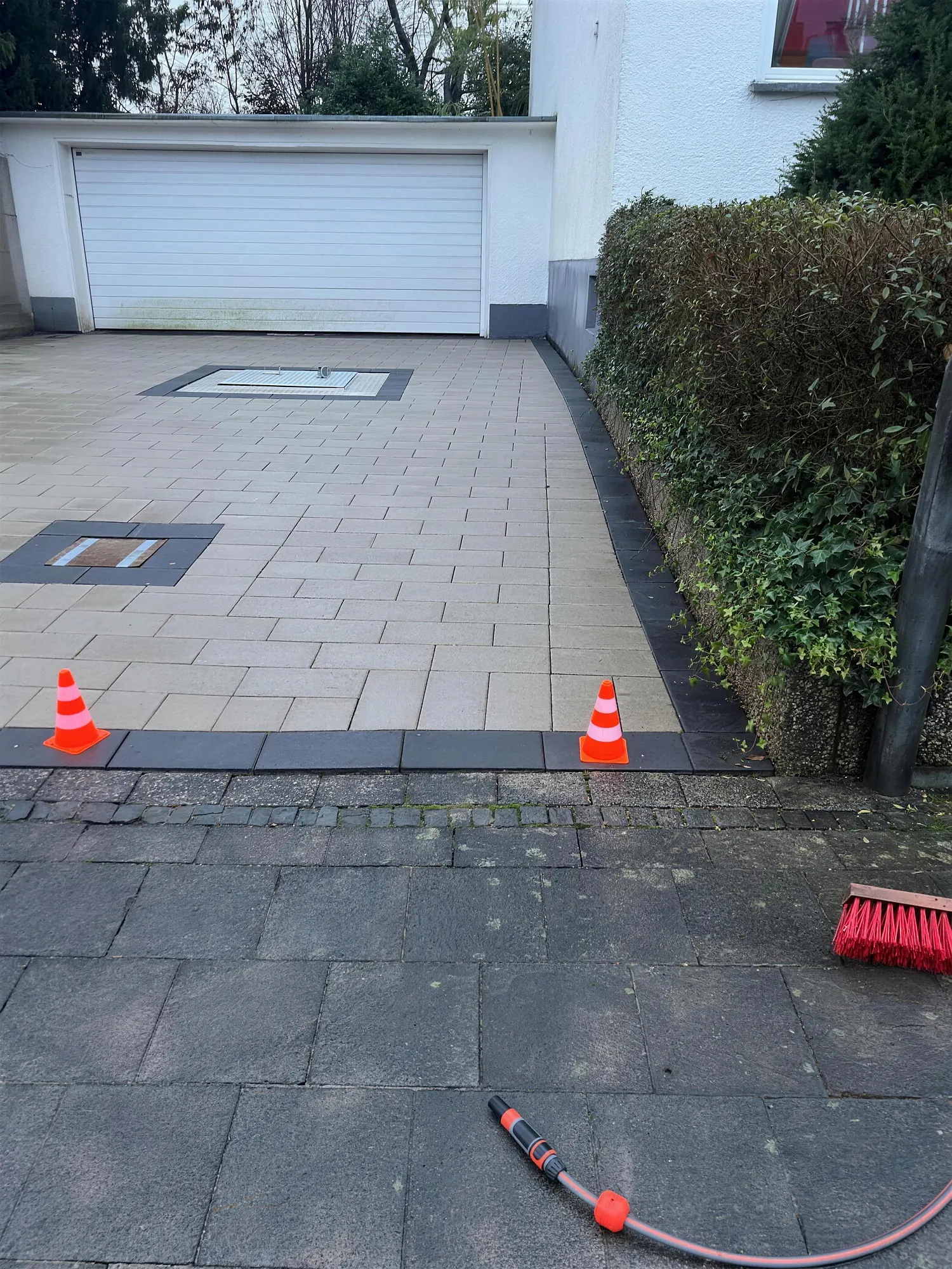 Gepflasterte Hofeinfahrt mit dunkler Randeinfassung